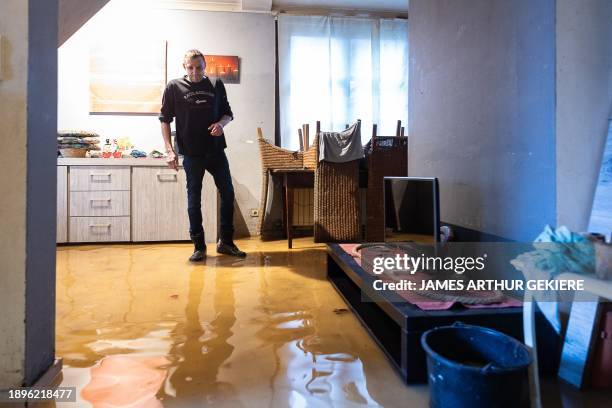 Kristof Desaegher cleans his house during heavy rainfall in Zandbergen, Geraardsbergen on Wednesday 03 January 2024. BELGA PHOTO JAMES ARTHUR GEKIERE