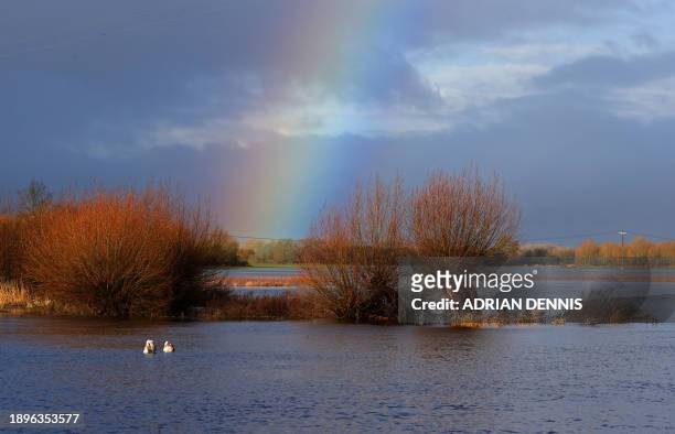Rainbow rises over flooded fields after the Rivers Thames and Churn burst their banks, in Cricklade, western England on January 3 following Storm...