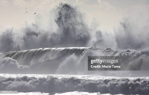 Pacific Ocean wave crashes against a jetty as other waves roll towards shore on December 30, 2023 in Ventura, California. Dangerous surf churned up...