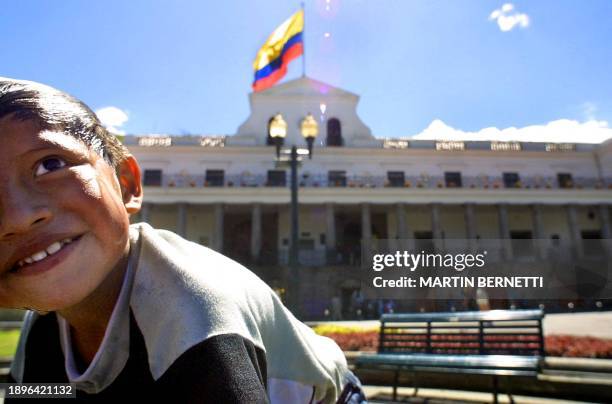 Un niño juega en una fuente en la Plaza de la Independencia, frente al palacio de gobierno llamado Carondelet, en Quito el 14 de julio de 2003....