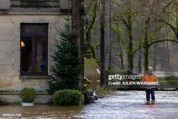 Rescue worker wades through a flood due to heavy rainfall in Moyen, Wednesday 03 January 2024. BELGA PHOTO JULIEN WARNAND