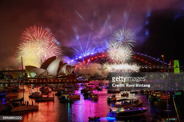 The 9pm Calling Country fireworks light up the sky over the Sydney Harbour Bridge and the Sydney Opera House during New Year's Eve celebrations on...