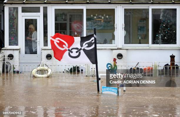 Person stands in the conservatory of a home surrounded by floodwaters after the Rivers Avon and Severn burst their banks in Tewkesbury, western...