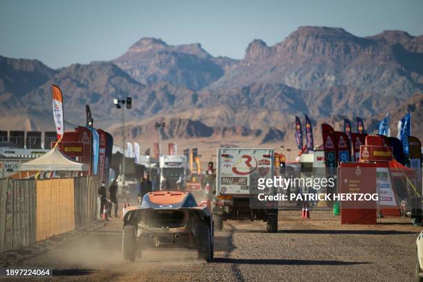 Competitors drive their vehicles to the entrance of the bivouac during check-ups, ahead of the the Dakar 2024 rally in Al-Ula, Saudi Arabia, on...