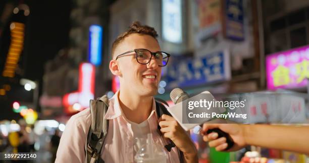 l'uomo visita il mercato notturno - intervista foto e immagini stock