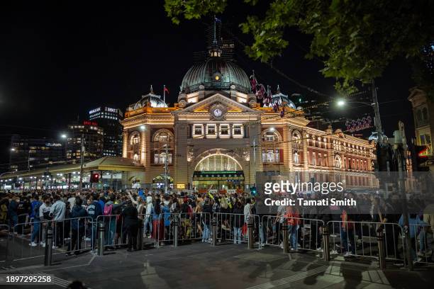 Crowd of people at Flinders Station in the CBD walk to the Yarra river to watch the New Year's fireworks on December 31, 2023 in Melbourne,...
