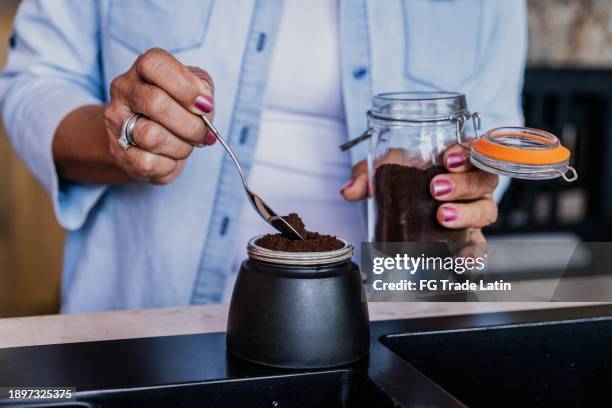 gros plan d’une femme préparant du café dans la cuisine à la maison - café moulu photos et images de collection