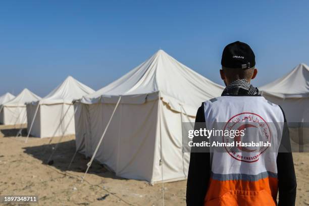 Members of the Egyptian and Palestinian Red Crescent erect tents for Palestinians displaced by the ongoing Israeli attacks on Gaza on December 31,...