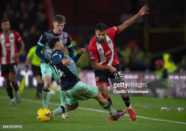 Ryan One of Sheffield United in action with Saman Ghoddos and Keane Lewis-Potter of Brentford during the Premier League match between Sheffield...
