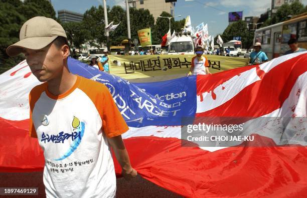 South Korean students carry a blood-dripped US flag during a march in Seoul, 15 August 2003, to mark Korea's liberation from Japanese colonial rule...