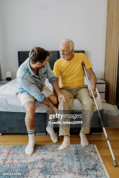 son helping his father - hip surgery stock pictures, royalty-free photos & images