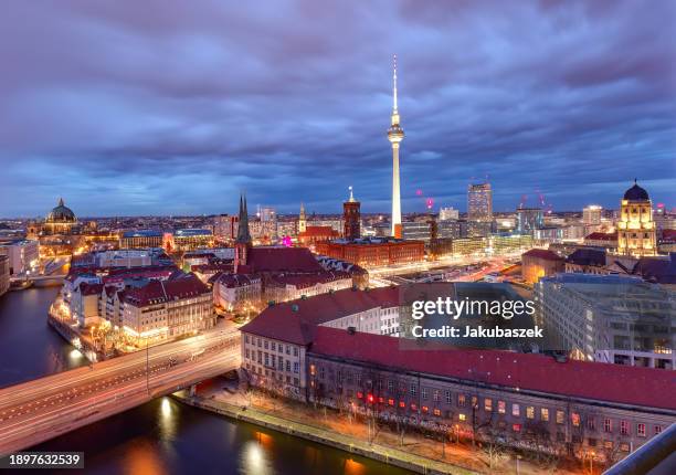 The skyline of Berlin is seen from fisher island with tv tower, red town hall, the dome of the Berlin Cathedral and firework at the horizon on...