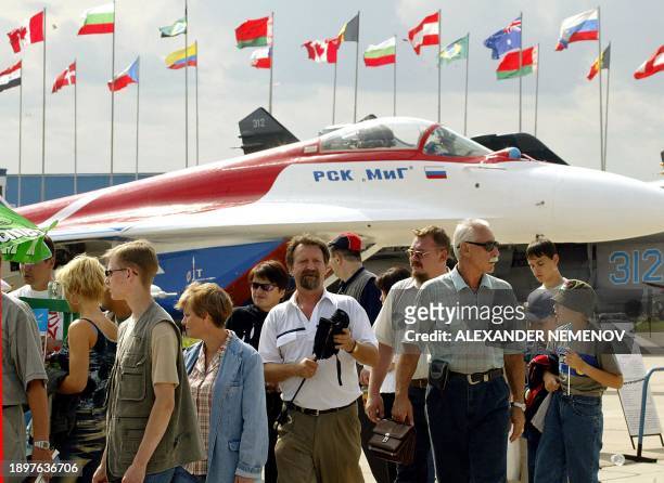Visitors walk in front ofa Russia MIG-29 in the town of Zhukovsky, outside Moscow, 22 August 2003, during 6-th International Air-Space Salon" MAKS...