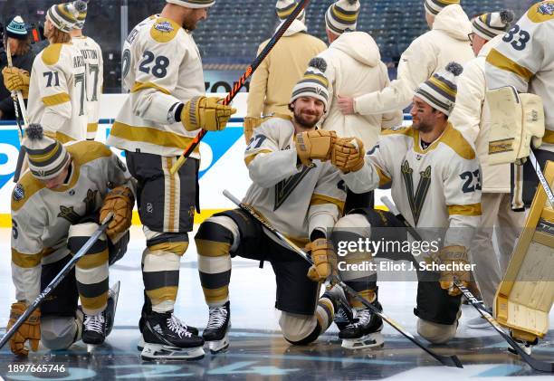 Shea Theodore and Alec Martinez of the Vegas Golden Knights bump fists during a team photo session before the 2024 Discover NHL Winter Classic...