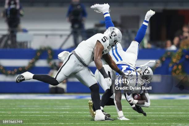 Trey Sermon of the Indianapolis Colts is upended by Amik Robertson of the Las Vegas Raiders during the second quarter at Lucas Oil Stadium on...