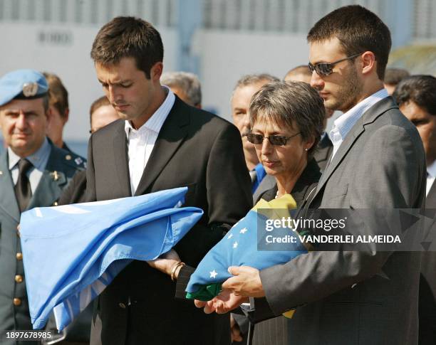 Slain UN diplomat Sergio Viera de Mello's sons Adrian and Bernard and widow Annie receive the the Brazilian and UN flags, during a funerary ceremony...