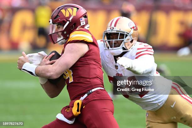 Clelin Ferrell of the San Francisco 49ers tackles Sam Howell of the Washington Commanders during the third quarter at FedExField on December 31, 2023...