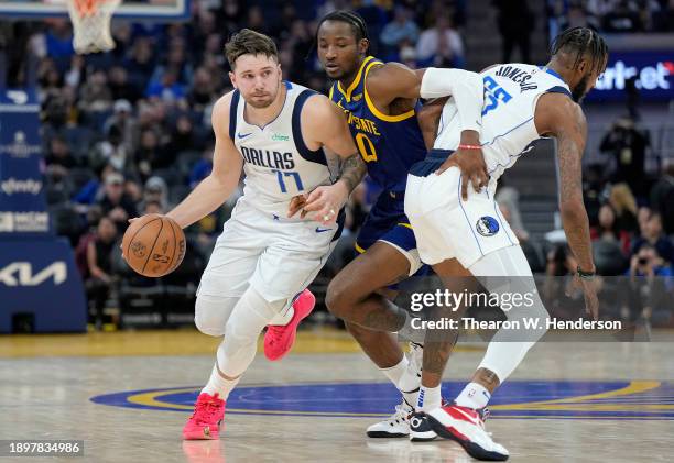 Luka Doncic of the Dallas Mavericks dribbles around a pick set by Derrick Jones Jr. #55 on Jonathan Kuminga of the Golden State Warriors during the...