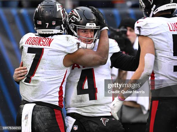 Bijan Robinson of the Atlanta Falcons hugs Taylor Heinicke of the Atlanta Falcons after Heinicke's rushing touchdown during the fourth quarter...