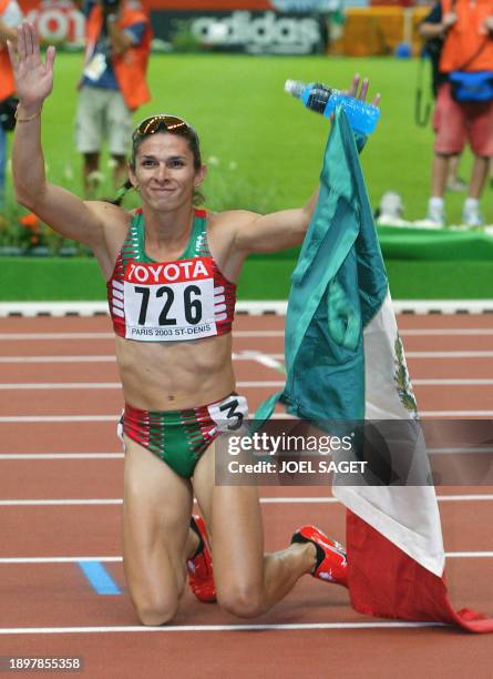 Ana Guevara of Mexico kneels on the track after winning the women's 400m final 27 August 2003, during the 9th IAAF World Athletics Championships at...