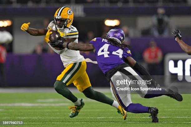 Green Bay Packers wide receiver Jayden Reed runs with the ball as Minnesota Vikings defensive back Josh Metellus gives chase during an NFL game...