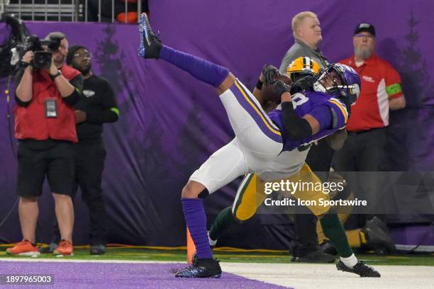 Minnesota Vikings wide receiver Justin Jefferson is knocked out of bounds by a Packers defender during an NFL game between the Minnesota Vikings and...
