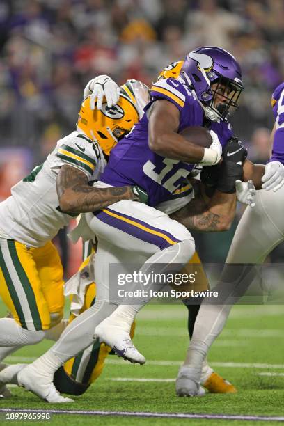 Minnesota Vikings running back Ty Chandler is wrapped up by Green Bay Packers defensive back Keisean Nixon during an NFL game between the Minnesota...