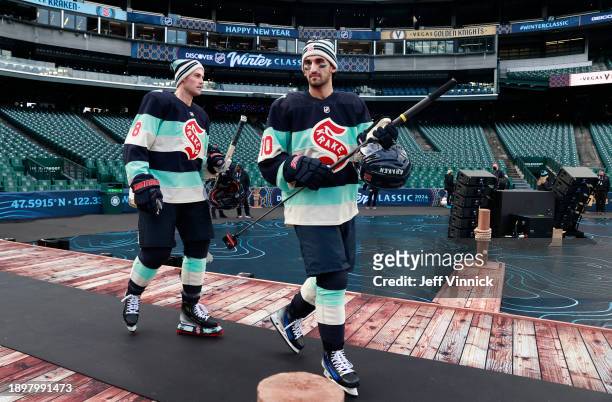 Brian Dumoulin and Matty Beniers of the Seattle Kraken make their way to the ice for a team photo session before the 2024 Discover NHL Winter Classic...