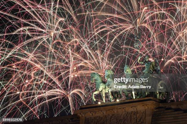 Fireworks explode over the Brandenburg Gate at midnight on New Year's Day, January 01, 2024 in Berlin, Germany. Police in Berlin, concerned about...