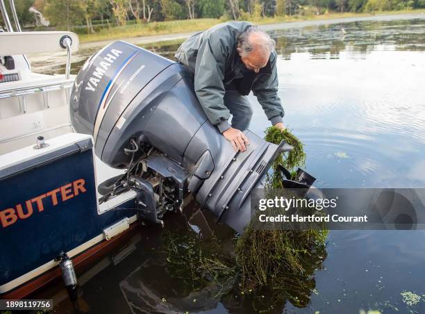 Joe Standart pulls Hydrilla from his boat propeller after a short trip around Selden Cove in Lyme, a cove that is part of the Connecticut River on...