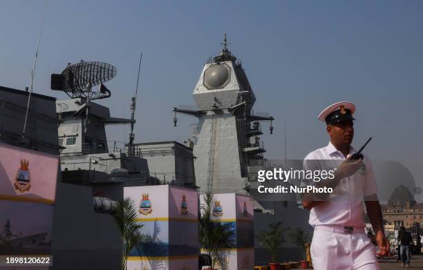 Navy personnel is walking in front of INS Imphal, a stealth guided missile destroyer and the third warship of Project-15B, at the Naval Dockyard in...