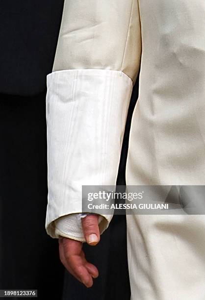 The right arm in a cast of Pope Benedict XVI is pictured as he leaves the hospital after being treated for a wrist fracture in Aosta on July 17,...