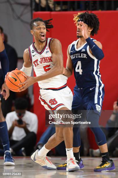 St John's Red Storm guard Daniss Jenkins passes the ball as Butler Bulldogs guard DJ Davis defends during the men's college basketball game between...