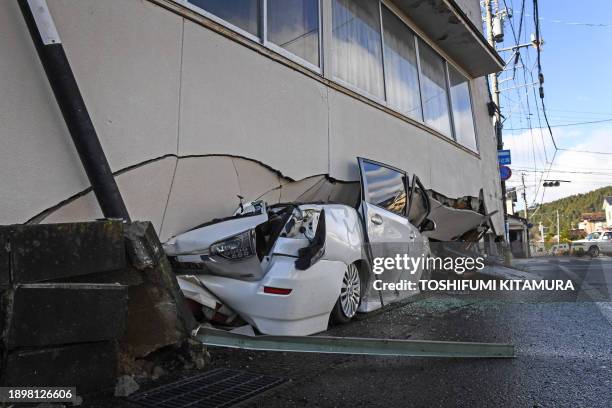 Car is seen under part of a building in Anamizu, Ishikawa prefecture on January 4 after a major 7.5 magnitude earthquake struck the Noto region in...