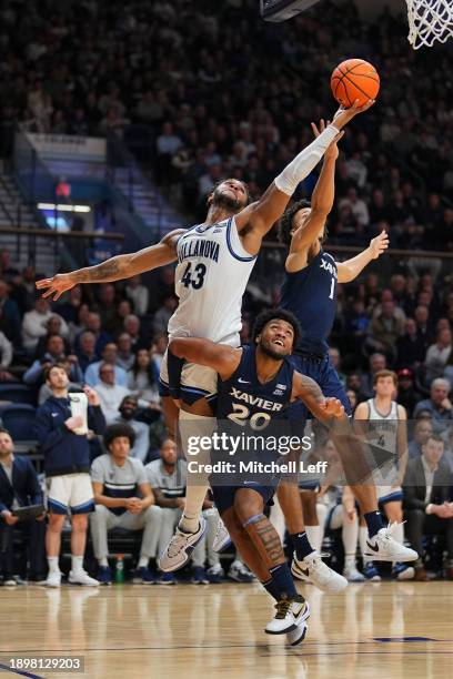 Eric Dixon of the Villanova Wildcats battles for a rebound against Dayvion McKnight and Desmond Claude of the Xavier Musketeers in the second half at...