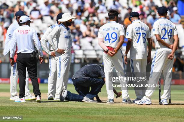 India's Mukesh Kumar looks on as a groundsman services the pitch during the second day of the second cricket Test match between South Africa and...