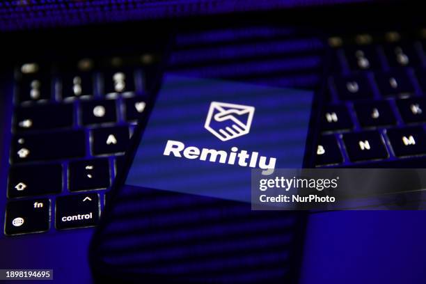 Binary code displayed on a laptop screen and Remity logo displayed on a phone screen are seen in this illustration photo taken in Krakow, Poland on...