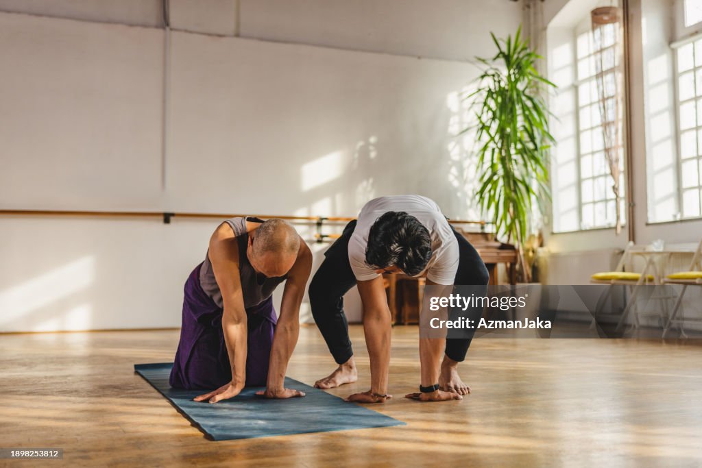 Indian Yoga Instructor Teaching New Posture To A Japanese Practitioner