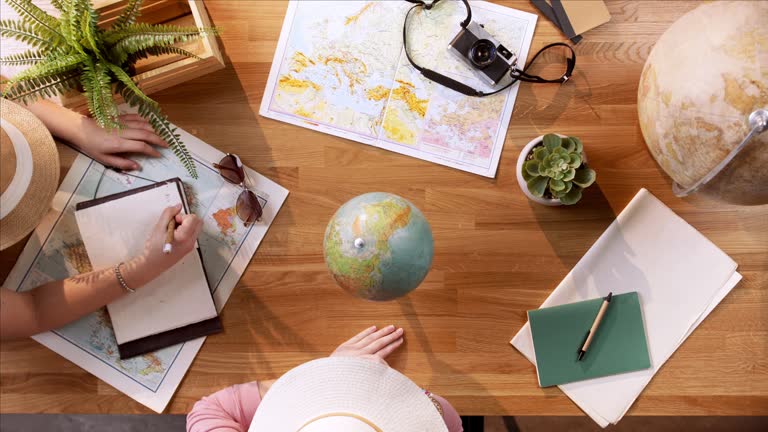 https://media.gettyimages.com/id/1898254326/video/top-view-of-young-couple-with-maps-planning-vacation-trip-holiday-desktop-travel-concept.jpg?b=1&s=640x640&k=20&c=rvb6f3biJur2fdS9MtI_BwG7XDFc6nawJYrR6LfJVKo=