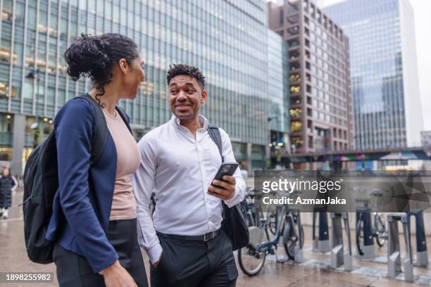two african colleagues talking and relaxing after their working day outside at the business dsitrict area - commuter man europe bike stock pictures, royalty-free photos & images