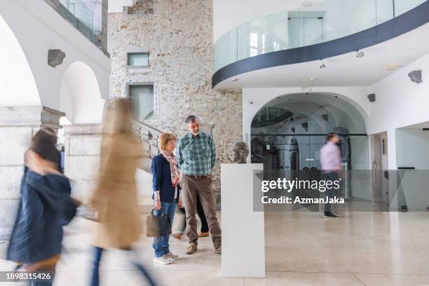 un couple caucasien plus âgé regardant une statue en buste dans un musée d’histoire alors que d’autres personnes passent - musée historique photos et images de collection