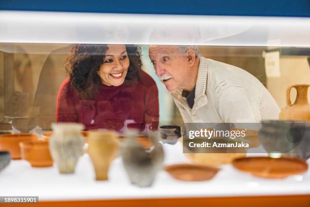 couple enthousiaste regardant une belle exposition de vases anciens dans un musée d’histoire - musée historique photos et images de collection