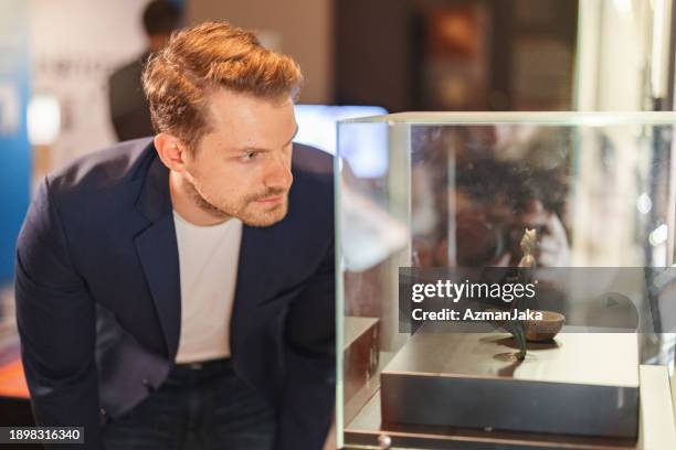 fancy adult caucasian male museum employee reviewing an exhibition in the museum - museum curator stock pictures, royalty-free photos & images