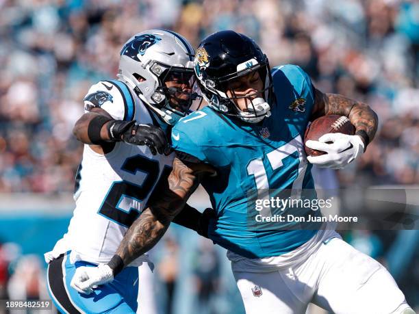 Tight End Evan Engram of the Jacksonville Jaguars is tackled from behind by Safety Xavier Woods of the Carolina Panthers after a catch and run during...