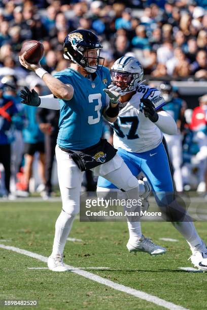 Quarterback C.J. Beathard of the Jacksonville Jaguars is being pressured by Linebacker Yetur Gross-Matos of the Carolina Panthers on a passing play...