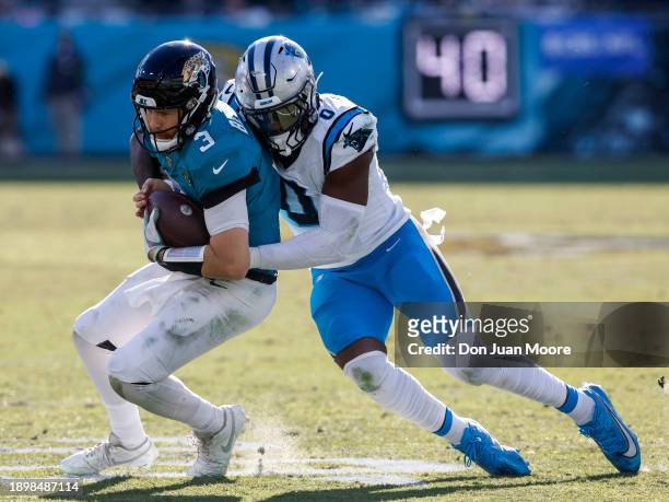Quarterback C.J. Beathard of the Jacksonville Jaguars is sacked by Linebacker Brian Burns of the Carolina Panthers during the game at EverBank...