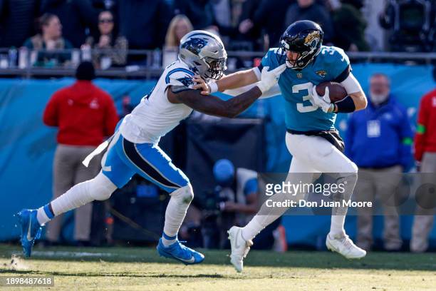 Quarterback C.J. Beathard of the Jacksonville Jaguars is being facemasked on a running play by Defensive End Brian Burns of the Carolina Panthers...