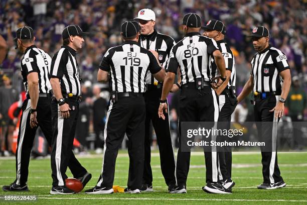 Referees confer after a penalty during the second quarter of a game between the Green Bay Packers and the Minnesota Vikings at U.S. Bank Stadium on...