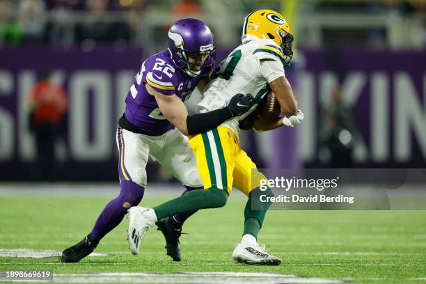 Bo Melton of the Green Bay Packers is tackled by Harrison Smith of the Minnesota Vikings during the fourth quarter at U.S. Bank Stadium on December...