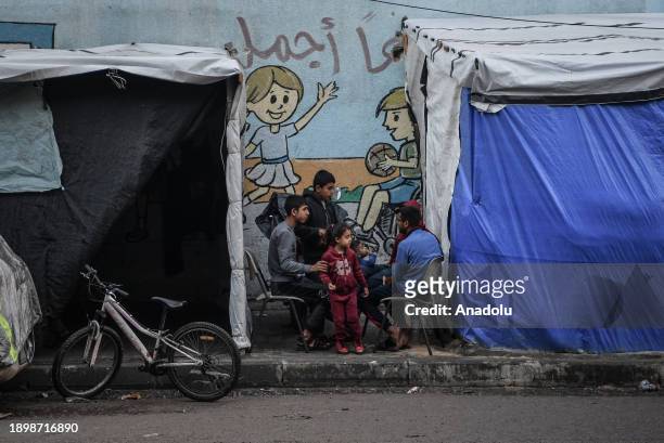 Palestinians chat with each other next to the makeshift tents while Israel's attacks continue on Gaza Strip as Palestinians who took refuge in the...